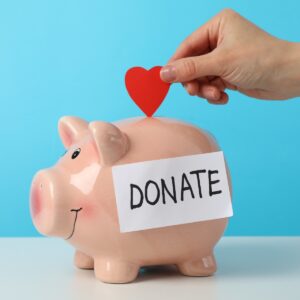 female hand puts heart in piggy bank with text don 2026 03 24 23 46 27 utc
